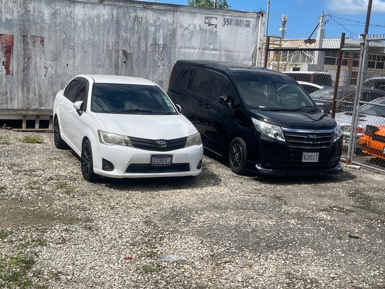 White Toyota sedan and black Toyota minivan in the Wanderers Getaway rental fleet